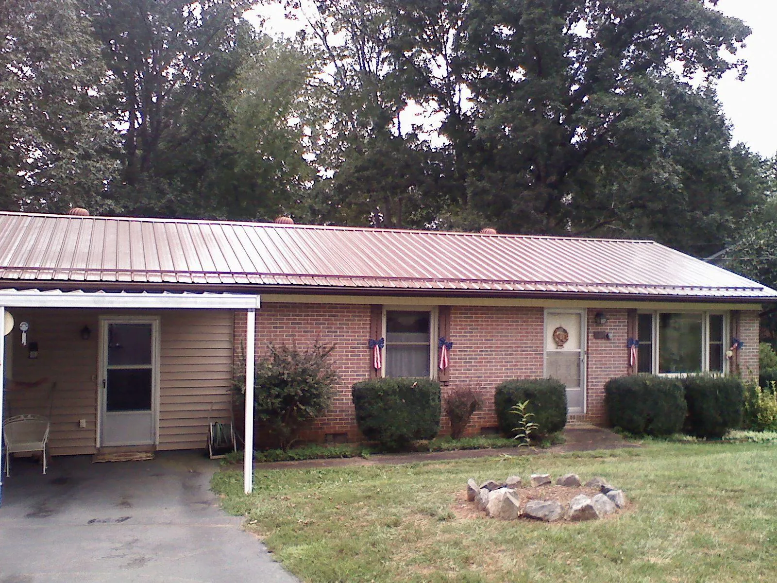 Bronze metal roof and carport on a brick ranch home — Roof Repair work by our crew in Rock Spring