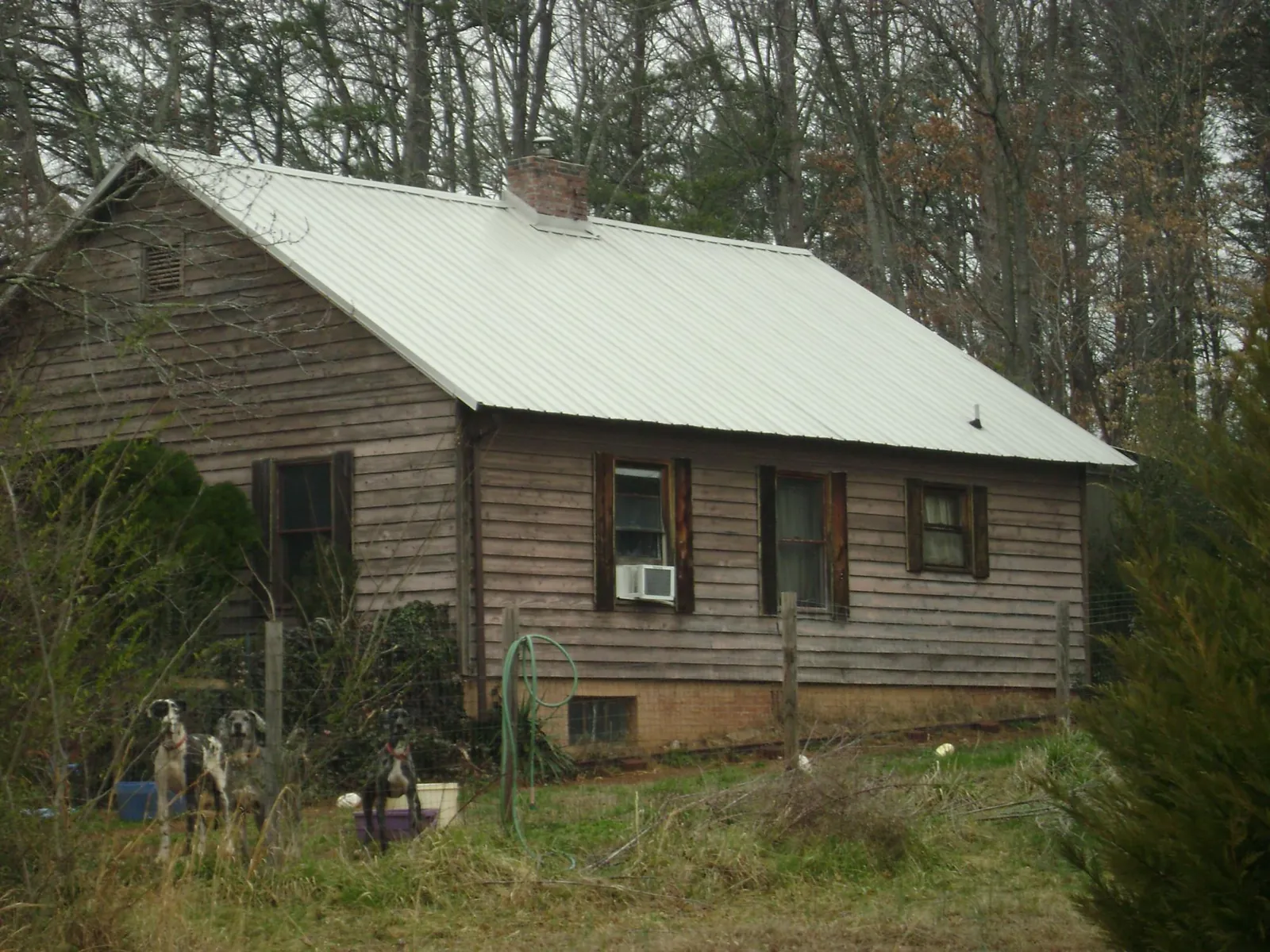 White metal roof on an old wood sided farmhouse, from a Metal Roof Installation job in Rock Spring